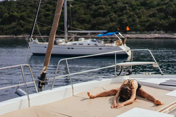 Fiatal egészséges és nyugodt nő csinál jóga vitorlás jacht hajó a tengeren a szigeten háttér — Stock Fotó