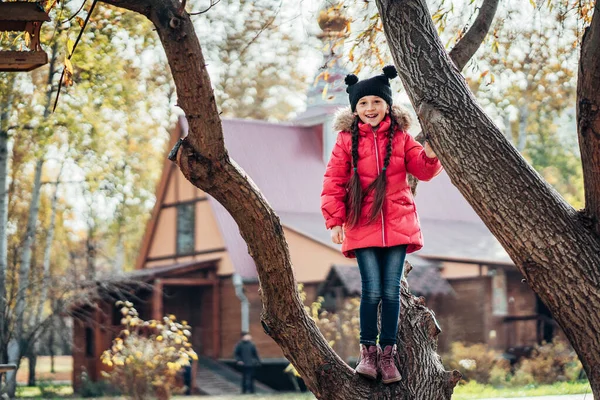 Liten flicka att klättra i träd — Stockfoto
