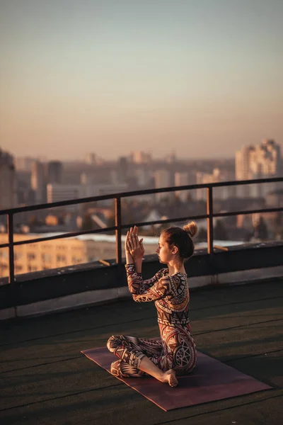 Mujer haciendo yoga en el techo de un rascacielos en la gran ciudad . —  Fotos de Stock