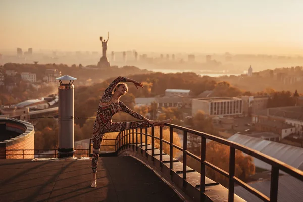 Mujer haciendo yoga en el techo de un rascacielos en la gran ciudad . —  Fotos de Stock