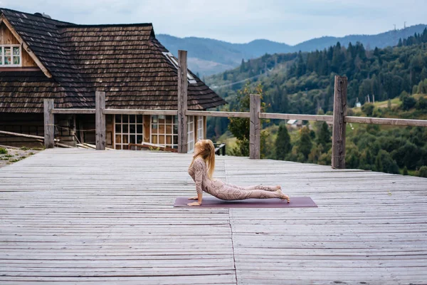 Женщина практикует йогу утром на террасе на свежем воздухе . — стоковое фото