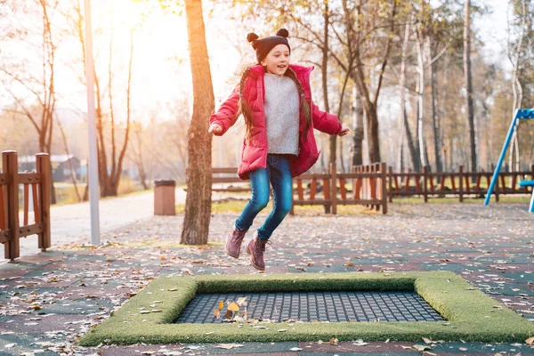 Joyeux écolière sautant sur un petit trampoline dans le parc — Photo