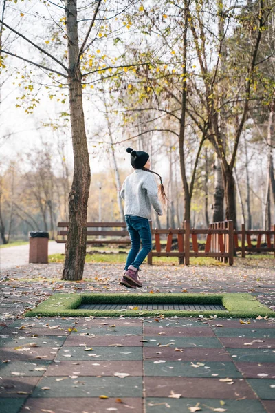Joyeux écolière sautant sur un petit trampoline dans le parc — Photo