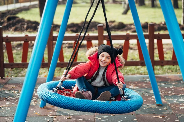 スイングして幸せな子供の女の子。秋のパックで遊んでいる小さな子供. — ストック写真