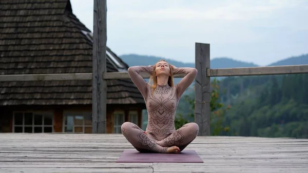 A woman sitting in lotus position at the morning on a fresh air. — Stock Photo, Image