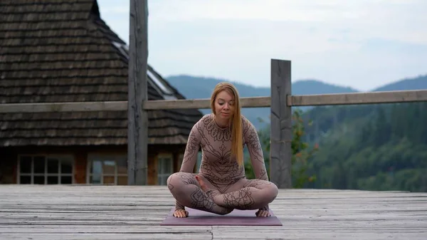 A woman sitting in lotus position at the morning on a fresh air. — Stock Photo, Image