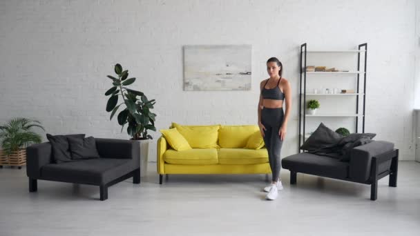 Schöne junge Frau macht Bauchmuskelübungen im Zimmer — Stockvideo