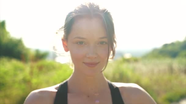 Красива молода дівчина посміхається в камеру в парку зовні — стокове відео