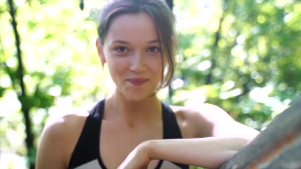 Belle jeune fille souriant à la caméra dans le parc à l'extérieur — Video