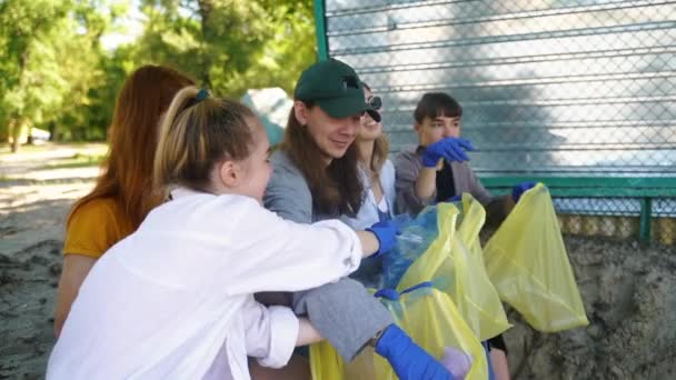 Ομάδα ακτιβιστών φίλοι ταξινομήσουν τα σκουπίδια σε σακούλες. Προστασία του περιβάλλοντος. — Αρχείο Βίντεο
