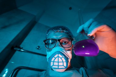 Genç erkek araştırmacı bilimsel deney yapıyor..