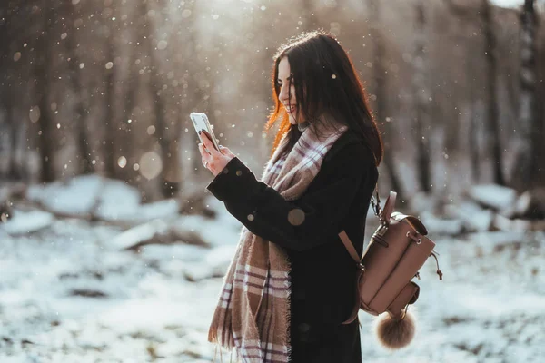Frau telefoniert. Lächelndes Mädchen, das an kalten Wintertagen mit dem Handy telefoniert. — Stockfoto