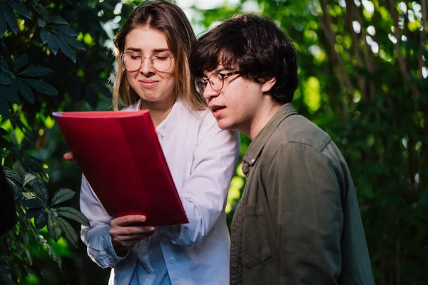 Young agricultural engineers working in greenhouse