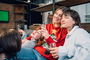 Grup arkadaşları oturma odasında bir kanepede oturuyor.