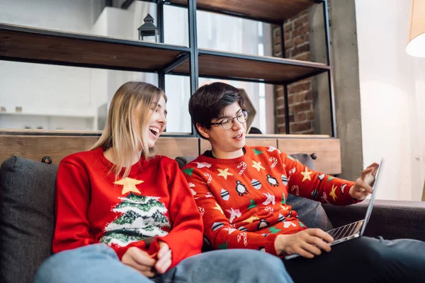 Glada par med laptop tillsammans på soffan, leende ung flicka och kille har kul att prata hemma — Stockfoto