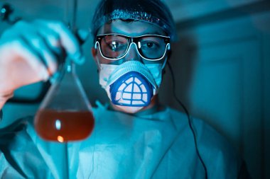 Genç erkek araştırmacı bilimsel deney yapıyor..