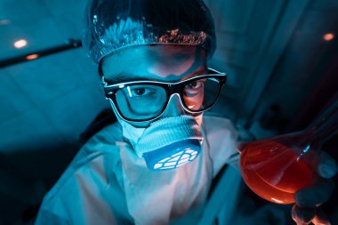 Genç erkek araştırmacı bilimsel deney yapıyor..