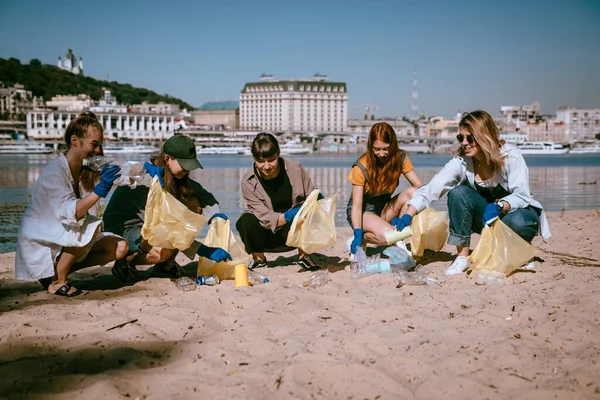 Egy csapat aktivista a parton gyűjti a műanyaghulladékot. Környezetvédelem. — Stock Fotó