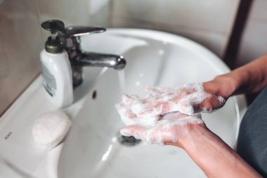 Koronavirüsten korunmak için ellerini yıkayan adam.