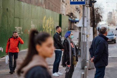 Kiev, Ukrayna, 28 Mart 2020 Ukraynalılar, Ukrayna 'da neredeyse boş bir sokakta yüz koruma maskesi takıyorlar.,