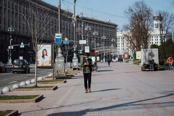 Київ, Україна, 28 березня 2020 року, український народ біля масок для захисту обличчя на майже порожній вулиці, під час карантину в Україні., — стокове фото