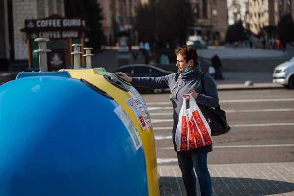 Κίεβο, Ουκρανία, 28 Μαρτίου 2020, Γυναίκα ταξινομεί σκουπίδια σε σχεδόν άδειο δρόμο, χρόνος καραντίνας στην Ουκρανία, — Φωτογραφία Αρχείου