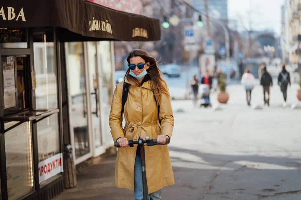 Kiev, Oekraïne, 28 maart 2020, Meisje rijdt een scooter op bijna lege straat, quarantaine tijd in Oekraïne, — Stockfoto