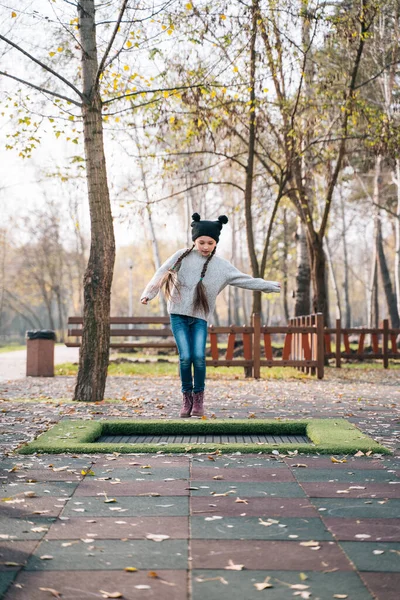 Joyeux écolière sautant sur un petit trampoline dans le parc — Photo