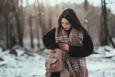 Genç ve güzel bir model kış ormanında poz veriyor. şık moda portresi