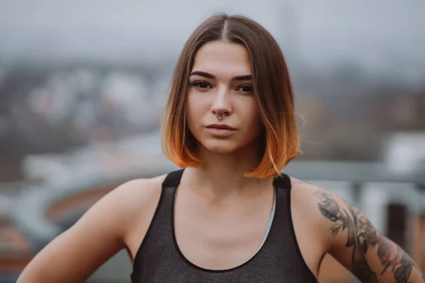 Menina posa no telhado de um edifício no centro da cidade. Fotografia de retrato — Fotografia de Stock