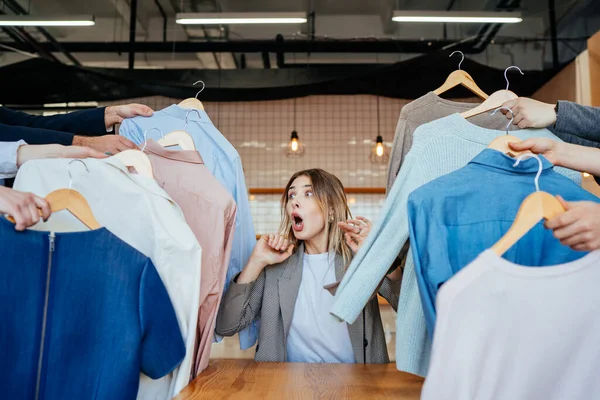 Mladý stylista hledá přes sadu košil pro módní natáčení — Stock fotografie