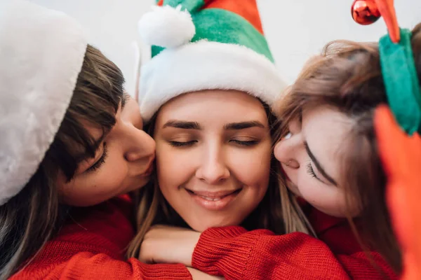 Porträtt av tre kvinnor vänner bär fritidskläder kramas tillsammans och kyssas på kinderna — Stockfoto