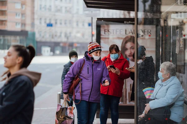 Κίεβο, Ουκρανία, 28 Μαρτίου 2020, άνθρωποι στο δρόμο με προστατευτικές μάσκες προσώπου waiting bus at bus stop — Φωτογραφία Αρχείου