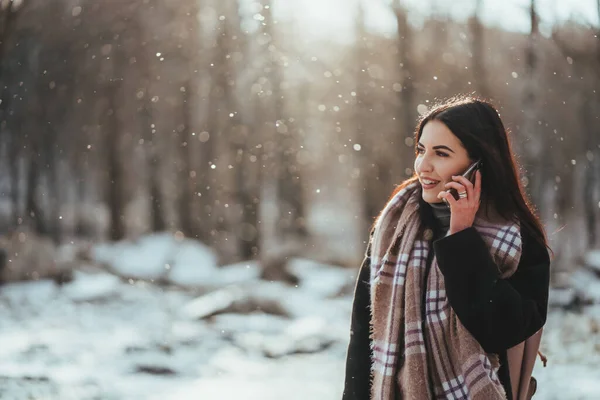 Egy nő beszél mobilon. Mosolygó lány beszél a mobiltelefon hideg téli nap. — Stock Fotó