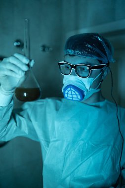 Genç erkek araştırmacı bilimsel deney yapıyor..