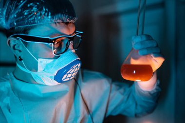 Genç erkek araştırmacı bilimsel deney yapıyor..