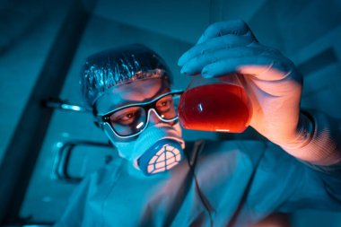 Genç erkek araştırmacı bilimsel deney yapıyor..