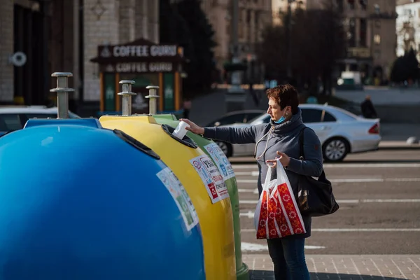 Κίεβο, Ουκρανία, 28 Μαρτίου 2020, Γυναίκα ταξινομεί σκουπίδια σε σχεδόν άδειο δρόμο, χρόνος καραντίνας στην Ουκρανία, — Φωτογραφία Αρχείου