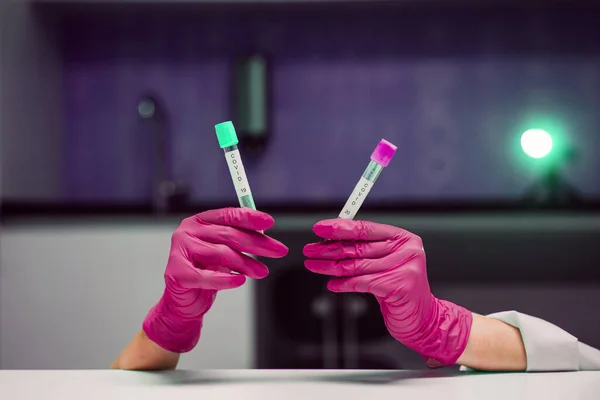 Руки в резиновых перчатках держит две пробирки с коронавирусом — стоковое фото