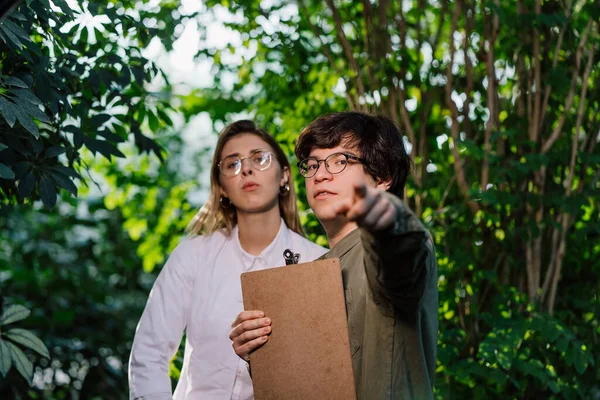 Unga jordbruksingenjörer som arbetar i stora växthus — Stockfoto