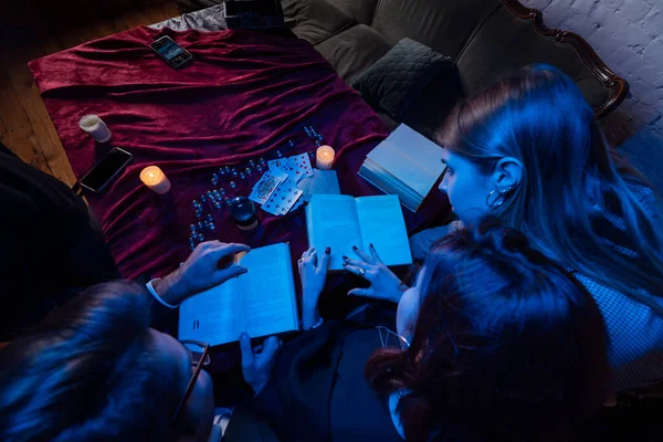 Duas mulheres e um cara estão lendo livros misteriosos, vista de perto — Fotografia de Stock