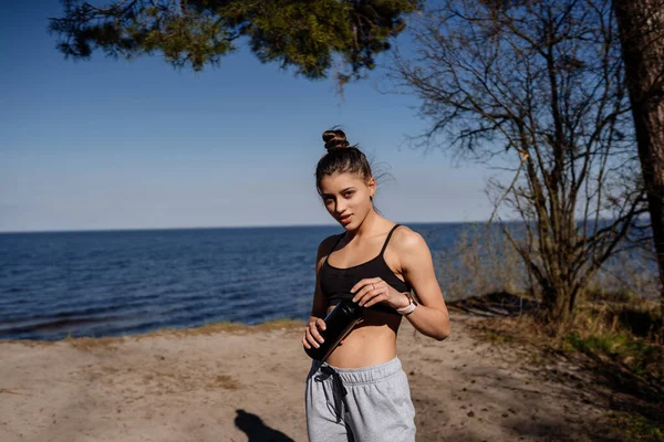 Vékony fiatal nő ivóvíz edzés után — Stock Fotó