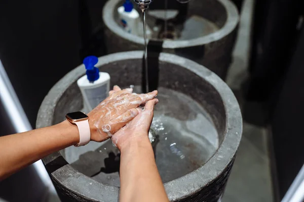 Kvinnan tvättar händerna för att skydda mot coronavirus — Stockfoto