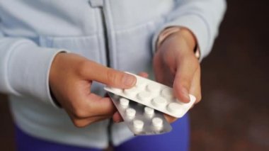 Coronavirus. Covid-19. Bir erkek ya da kadın hap alır ve gösterir..