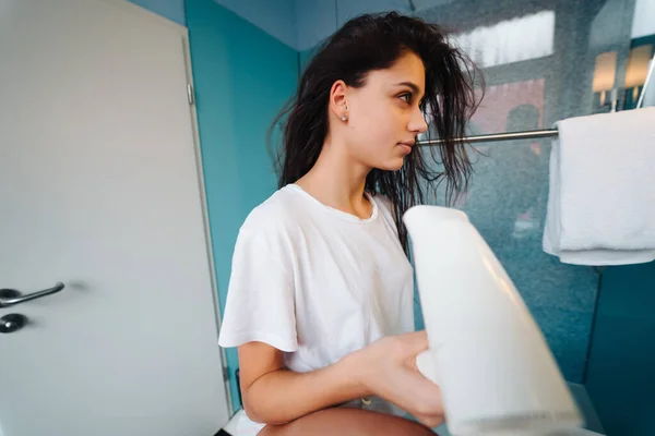 Porträt einer jungen Frau mit Haartrockner im Badezimmer — Stockfoto