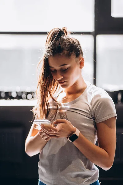집에서 스마트폰으로 메시지를 읽고 있는 행복 한 소녀 — 스톡 사진