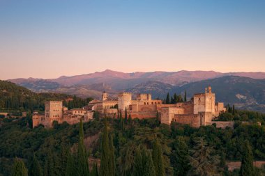 Alhambra 'nın anıtsal kompleksinin günbatımında panoramik manzara, arka planda Sierra Nevada, açık bir gün, bir Dünya Mirası Alanı ilan etti..