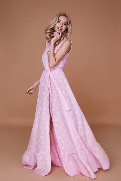 Сексуальная красавица с загаром на лице носит детское розовое шелковое платье — стоковое фото