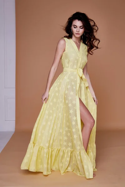 Сексуальная красотка женщина красивое лицо загар кожи носить желтое шелковое платье вот — стоковое фото