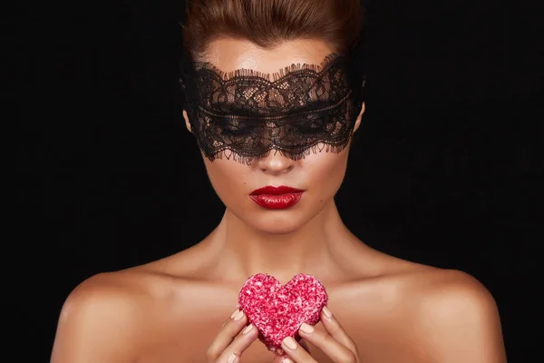 Beautiful sexy woman dark lace on eyes with cake shape of heart — Stock Photo, Image